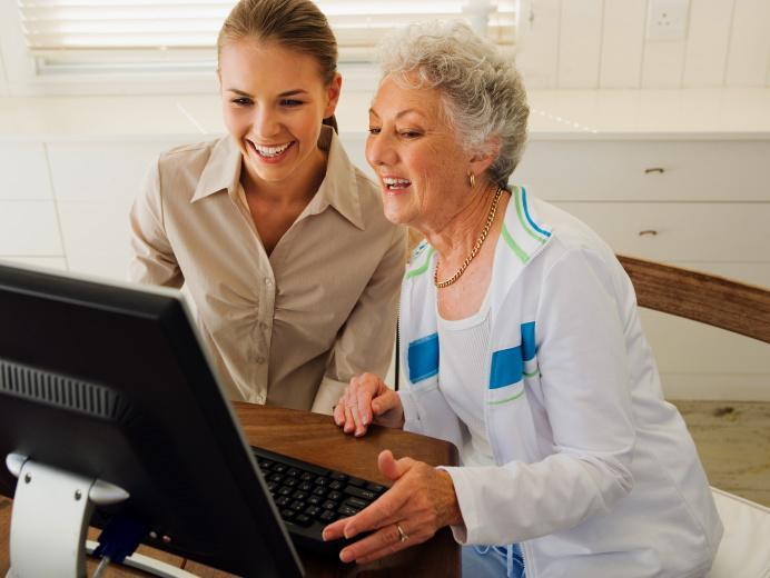 Carer and woman looking at laptop